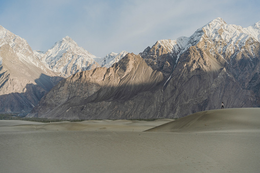 Woman in Katpana Desert in Northern Pakistan on the background of Karakoram mountains