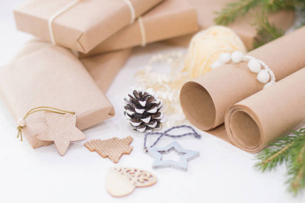 istock gift wrapping process for christmas and new year, eco friendly gift boxes and natural christmas decor on white table, focus on pine cone, cozy workshop concept 1318014868