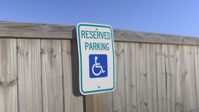 Reserved parking sign on wooden fence with blue sky as background