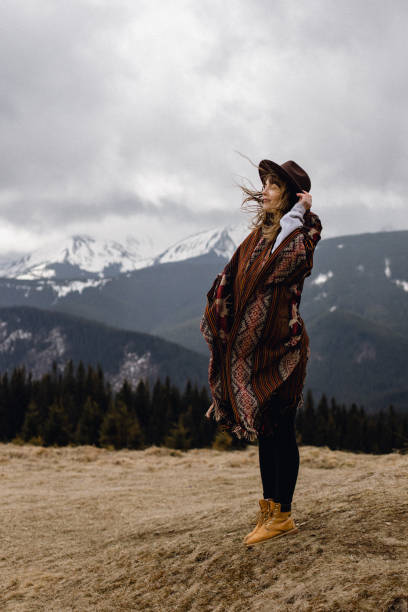 istock A young beautiful woman is standing  alone among dramatic mountains landscape 1318015711