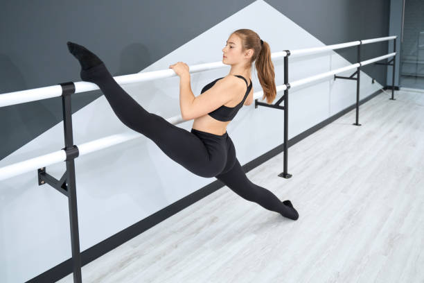 istock Female teenger stretching using handrails in hall. 1318016095