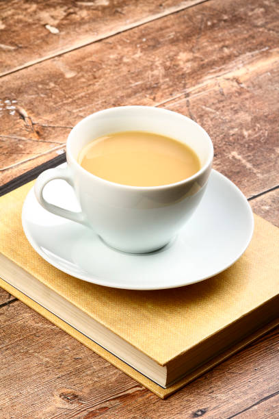 istock White cup and saucer filled with tea sat on a reading book 1318017015