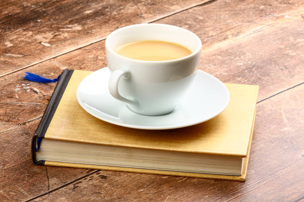 istock White cup and saucer filled with tea sat on a reading book 1318017017