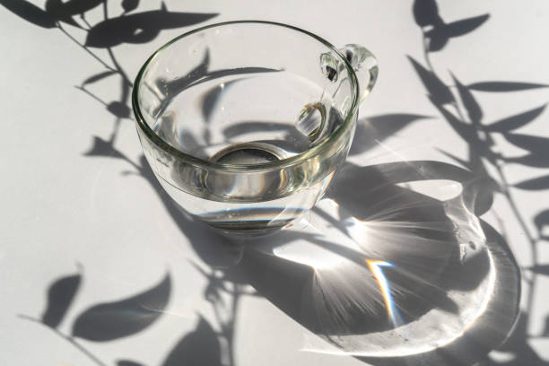 istock Abstract shadow pattern on white background and glass cup with water. Texture for the background 1318019822