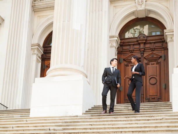 istock Well Dressed Man and Woman Descend Courthouse Steps in Conversation 1318019942
