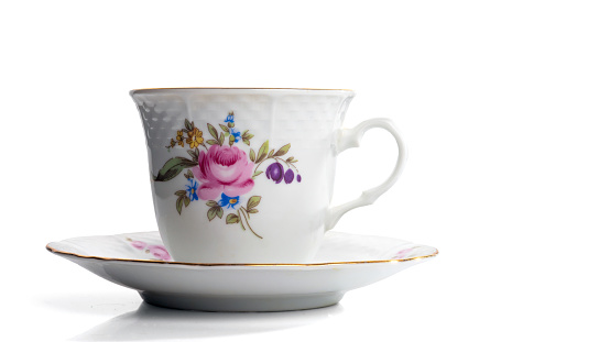 A cup of tea in a bone china cup and saucer - white background