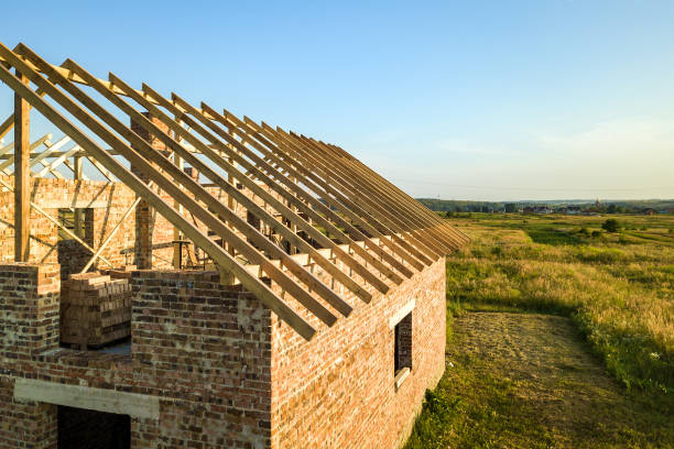 istock Unfinished brick house with wooden roof structure under construction. 1318020808