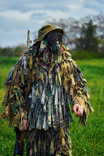 istock Airsoft player in camouflage military uniform with sniper rifle 1318031987