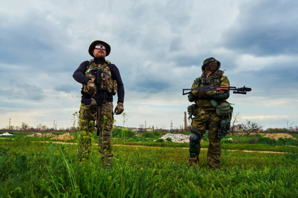 istock Two soldiers with weapons in their hands stand in the field 1318032019