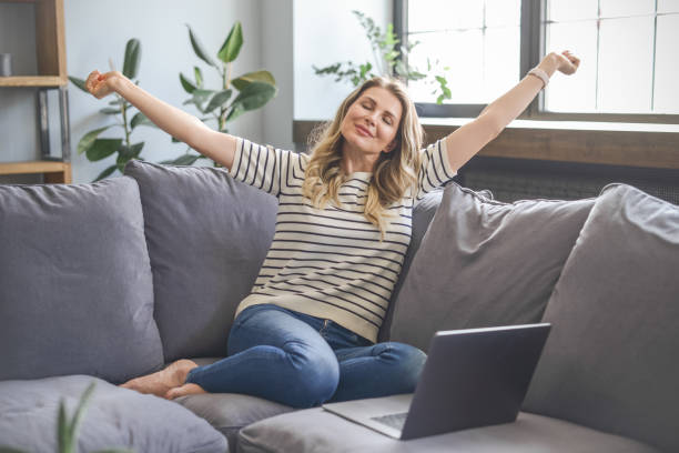 istock attractive middle aged woman sitting on the couch (Taking A Break) 1318033273