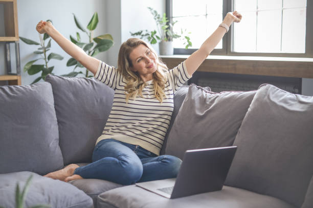 istock attractive middle aged woman sitting on the couch (Taking A Break) 1318033355