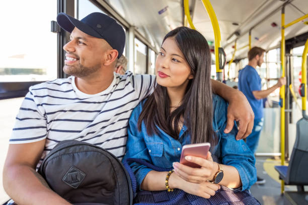 istock Smiling couple looking away while traveling in bus 1318034077