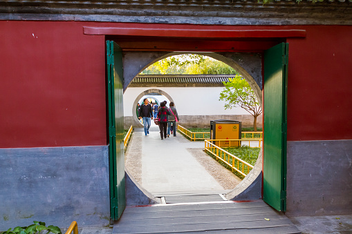 Visitors walking along the gardens and gates of the Nanhu Island, place of the Dragon King's Temple, at the Beijing's Summer Palace.