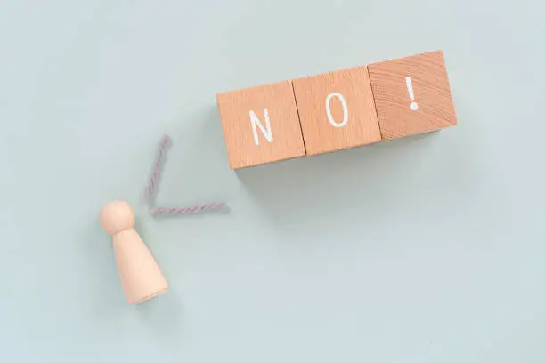 NO; Wooden blocks with "NO"  text of concept and a human toy.