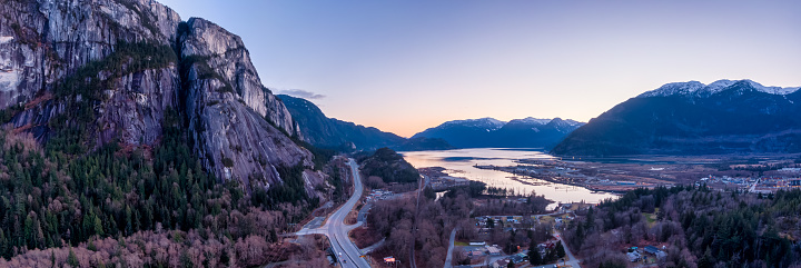 Aerial Panoramic view of Sea to Sky Highway with Chief Mountain in the background. Colorful Sunset Twilight Sky. Taken near Squamish, North of Vancouver, British Columbia, Canada.