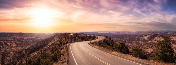 Panoramic View of a scenic route on top of a mountain ridge in the desert. Panoramic View of a scenic route on top of a mountain ridge in the desert. Colorul Sunset Sky Art Render. Taken on Route 12, Utah, United States of America. winding road photos stock pictures, royalty-free photos & images