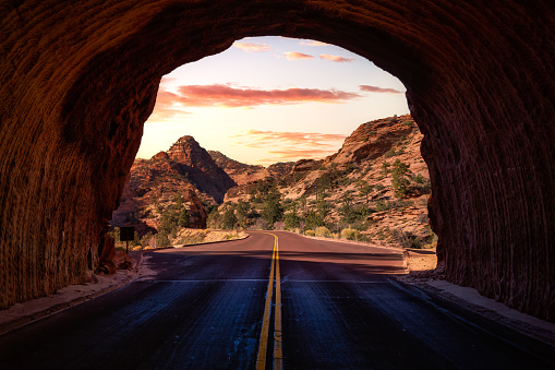 Middle of the road from tunnel view of a scenic route in American Canyons Mountain Landscape. Sunset Sky Art Render. Taken in Zion National Park, Utah, United States.