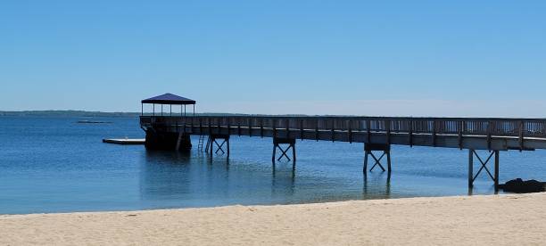 istock Pier, sand and blue water 1318053557