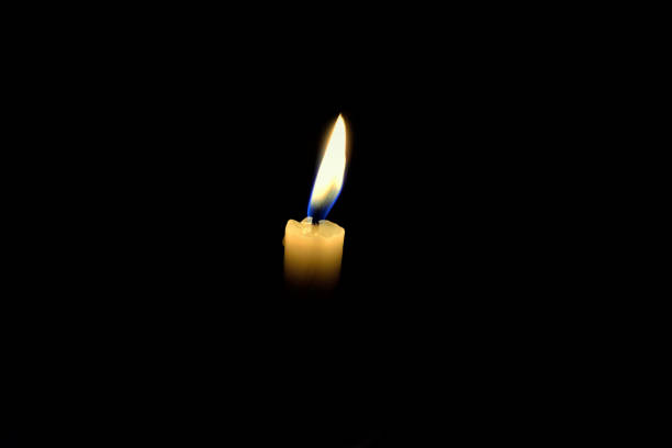 istock The flame of a candle lit in the dark 1318054599