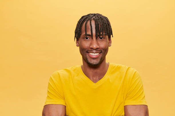 istock Handsome Afro Man Posing Over Yellow Background wearing yellow tshirt 1318056507