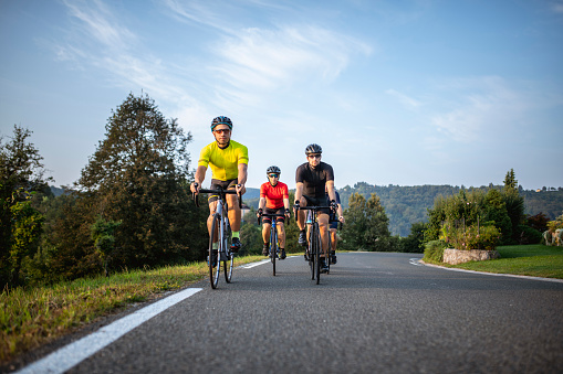 Young and mid adult friends approaching camera as they enjoy weekend road riding in countryside near Ljubljana.
