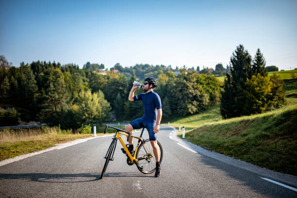 istock Young Male Cyclist Pausing for Water Break During Workout 1318056932