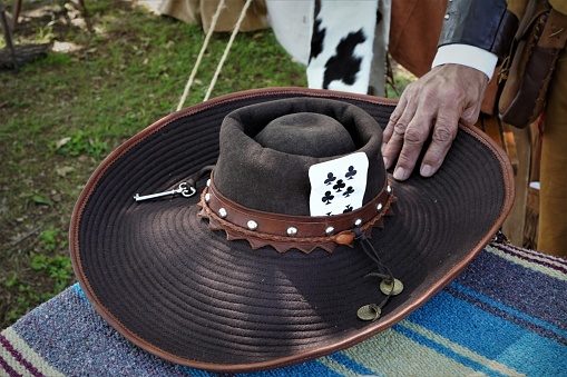 Juan Seguin is reenacted by a Hispanic senior man during a Texas Independence Day re-enactment at Acton, Texas, cemetery where Elizabeth Crockett, Davy's wife, is buried. Props include cowboy hat with playing card so Seguin doesn't get shot by \