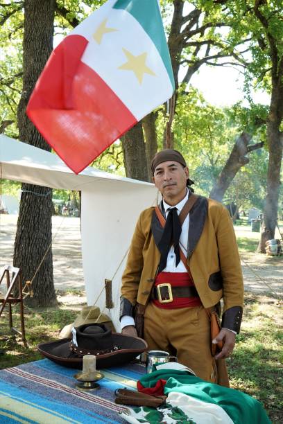 Juan Seguin is reenacted by a Hispanic senior man during a Texas Independence Day re-enactment at Acton, Texas, cemetery where Elizabeth Crockett, Davy's wife, is buried. Props include cowboy hat with playing card so Seguin doesn't get shot by \