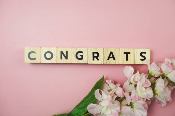 istock Congrats alphabet letter with Blooming flower on pink background 1318065431