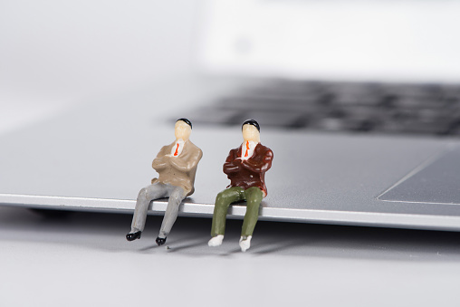 miniature businessman stand on laptop