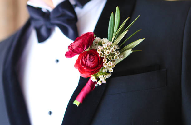 Wedding boutonnière on groom A boutonnière or Buttonhole is a floral decoration, usually a single flower or bud that is worn on the lapel of a tuxedo or suit jacket. While worn more often in the past, boutonnières are now typically reserved for special occasions for which formal wear is standard, like at proms, homecomings, funerals, and weddings. buttonhole flower stock pictures, royalty-free photos & images