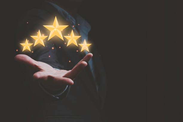 istock Businessman holding virtual five stars for customer feedback rating and evaluation concept. 1318068425
