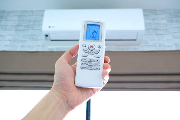 istock Man's hand using remote control open The air conditioner is cooled to 25 degrees Celsius in his bedroom. Health concepts and energy savings 1318074289