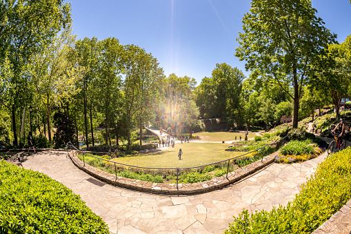 Greenville, SC - April 25, 2021: Fisheye view of people in a grassy field at the famous Falls Park on the Reedy River, downtown.