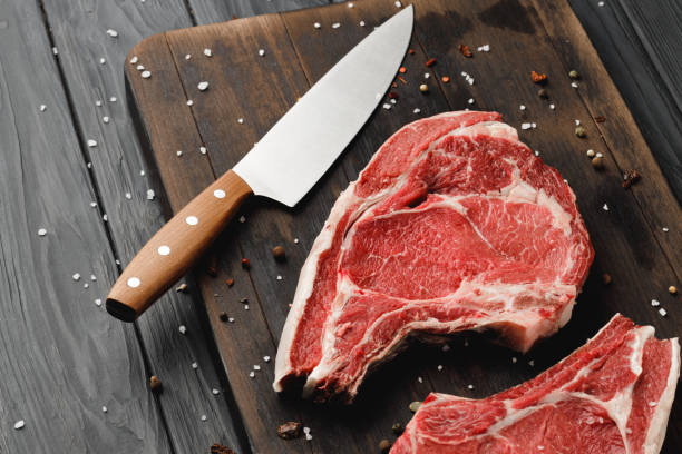 istock Raw rib eye steak on brown wooden board 1318080323