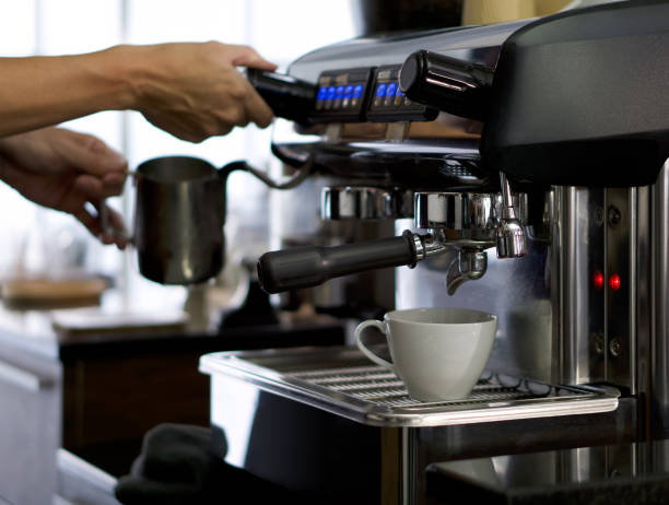 istock A white ceramic cup placed on the coffee maker. Prepare for making espresso coffee. Barista holding  milk frothing pitcher in the background. 1318082576