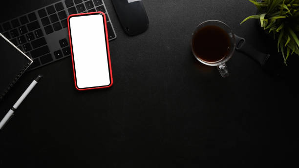 istock Mock up smart phone and black equipment on black leather. 1318085784