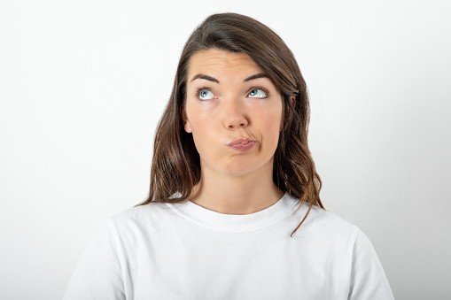 Portrait of displeased upset young woman start crying on gray background close up