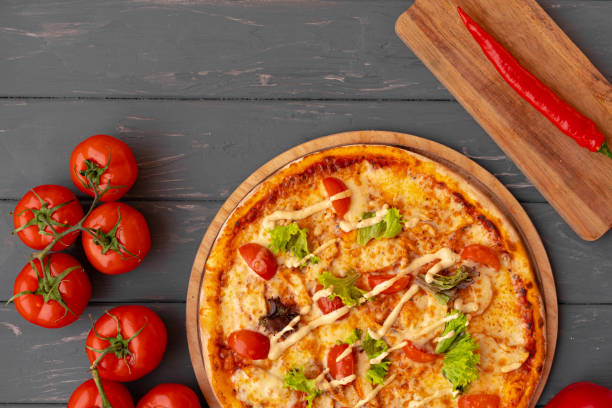 istock Delicious pizza on gray wooden background top view 1318090150