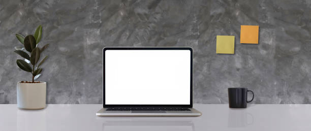 istock Mock up laptop computer with blank white screen of placed on office white table 1318090170