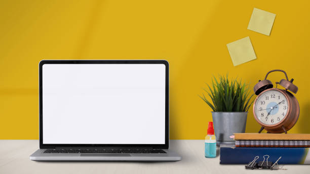 istock workspace with laptop computerblank screen, office supplies and alcohol spray at home. Mock up 1318090186