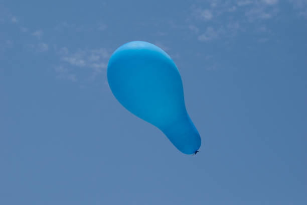 istock sky blue balloon flying in the blue sky. 1318093184