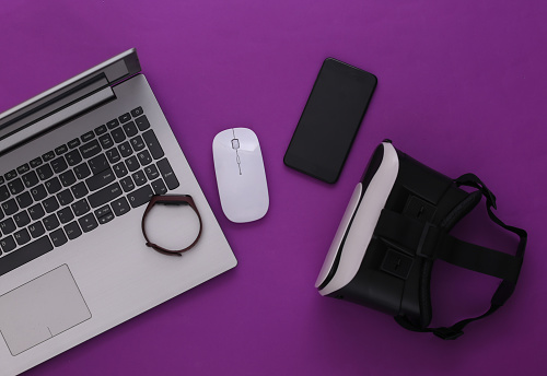 Modern youth gadgets and devices on purple background. Top view. Flat lay
