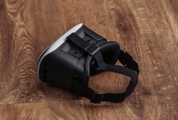 istock Virtual reality headset with joystick on wooden background. Modern gadgets 1318095914