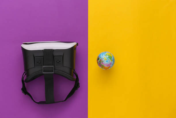 istock Virtual travel. Virtual reality headset with globe on yellow purple background. Top view 1318097031