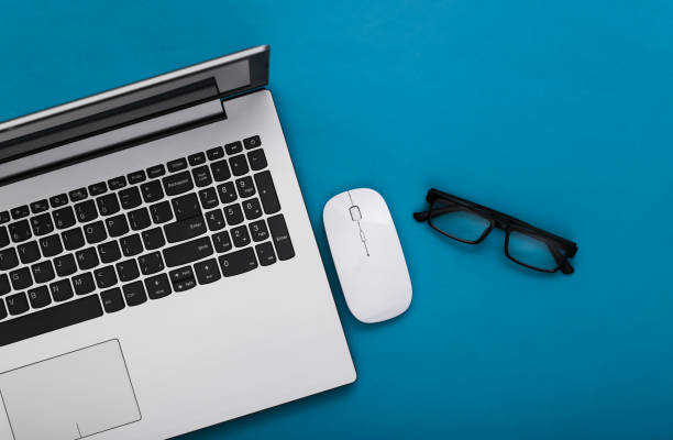 istock Business theme. Laptop with glasses on blue background. Top view 1318097198