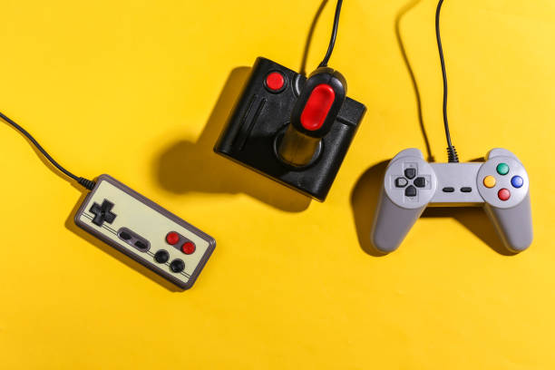 istock Retro joystick and gamepads on yellow background with shadow. Retro gaming. Top view 1318098000