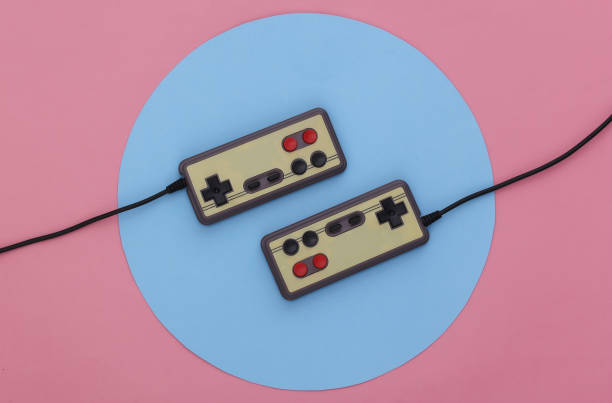 istock Retro gamepads on pink background with a blue circle. Conceptual studio shot. Minimalism. Top view 1318098093