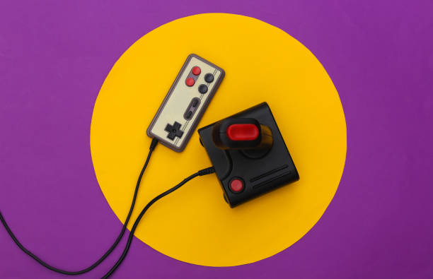 istock Retro joystick and gamepad on purple background with yellow circle. Conceptual studio shot. Minimalism. Top view 1318098103