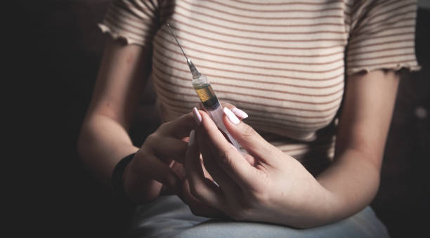 istock Drug addict with a syringe at home. 1318098365